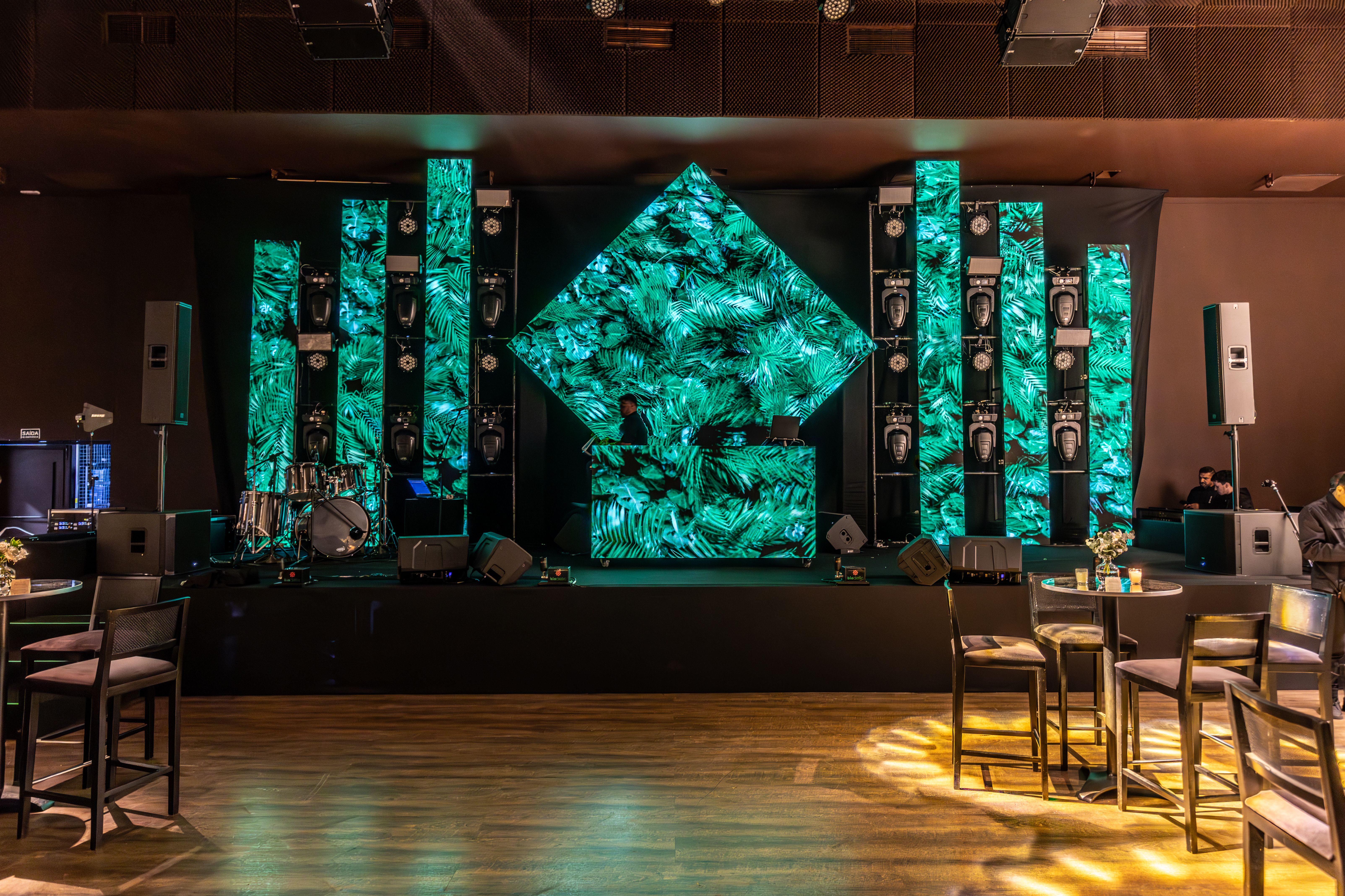 DJ-Pult mit gruenen LED-Panels als Beispiel fuer Buehnen- und Eventinfrastruktur